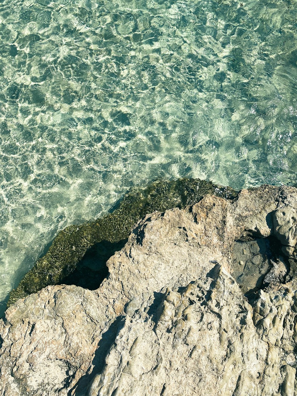 a rocky cliff with a body of water below