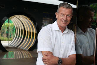 a man smiling with his arms crossed