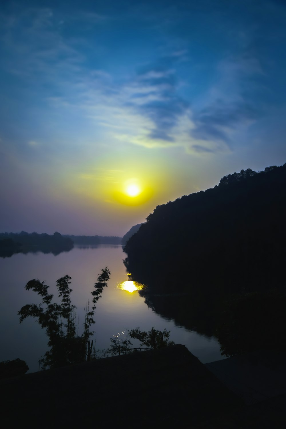 a body of water with trees and hills around it