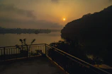 Private balcony overlooking a calm lake at sunset with comfortable seating.