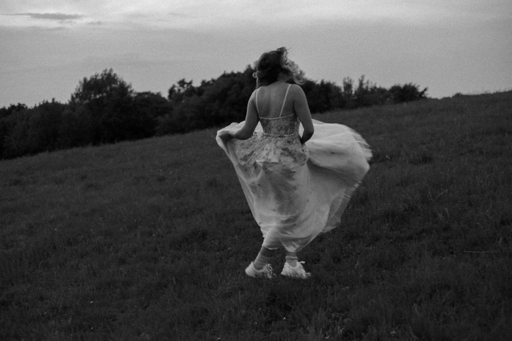 a person in a dress walking in a field