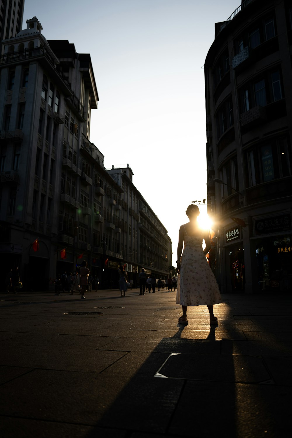 a person walking down a street with buildings on either side of it