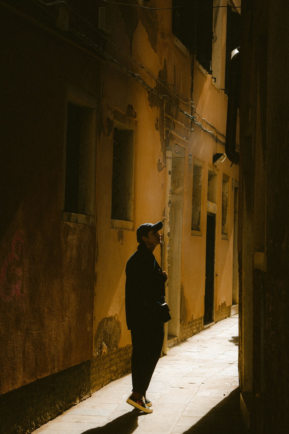 a man in a uniform standing in an alleyway