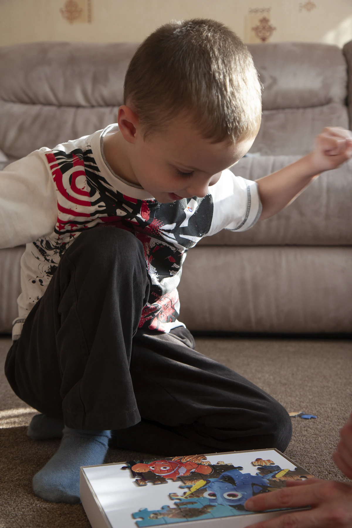 Child concentrating on a hands-on puzzle at home