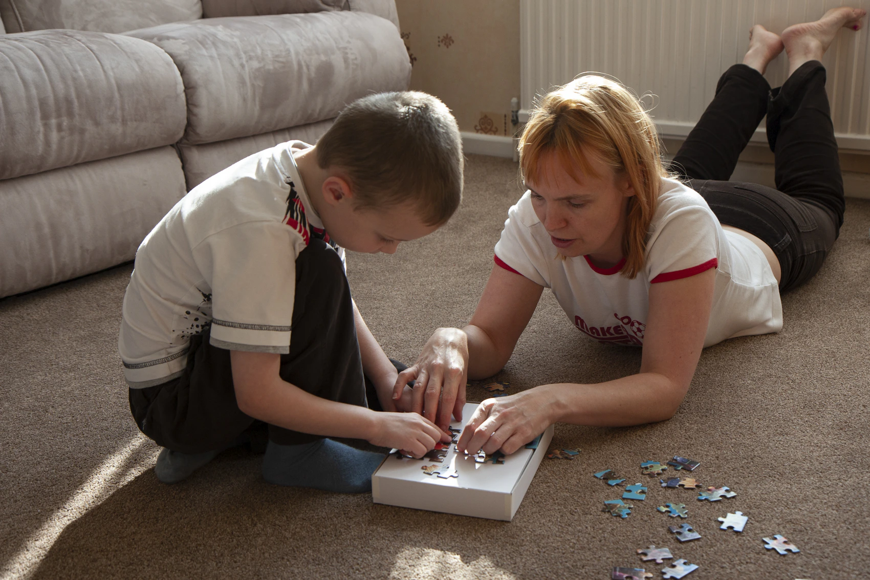 Parent and child working together on a colorful educational puzzle at home