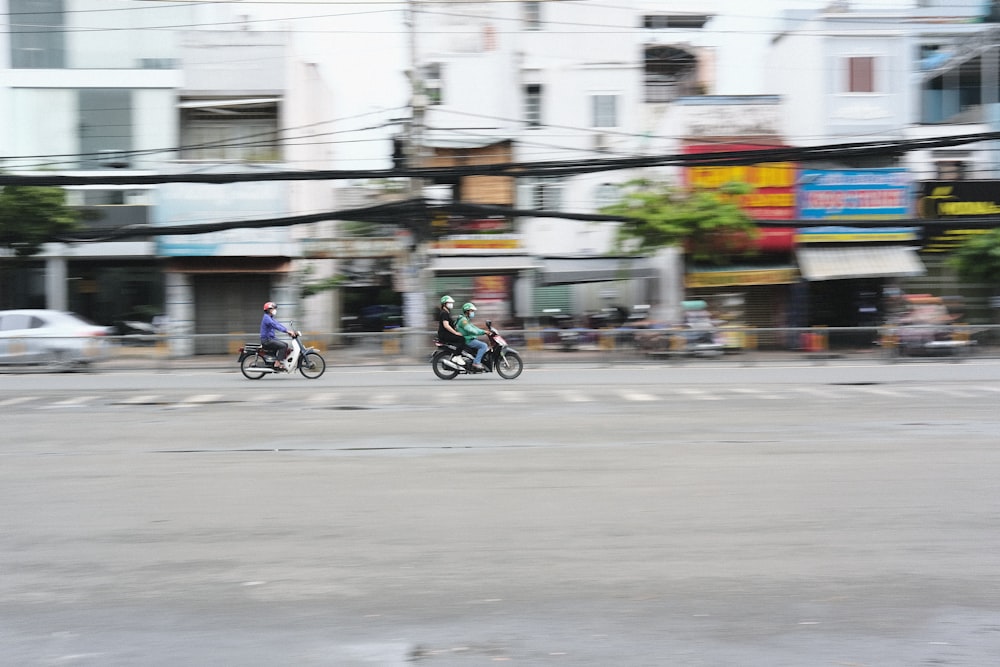 a group of people ride motorcycles down a street