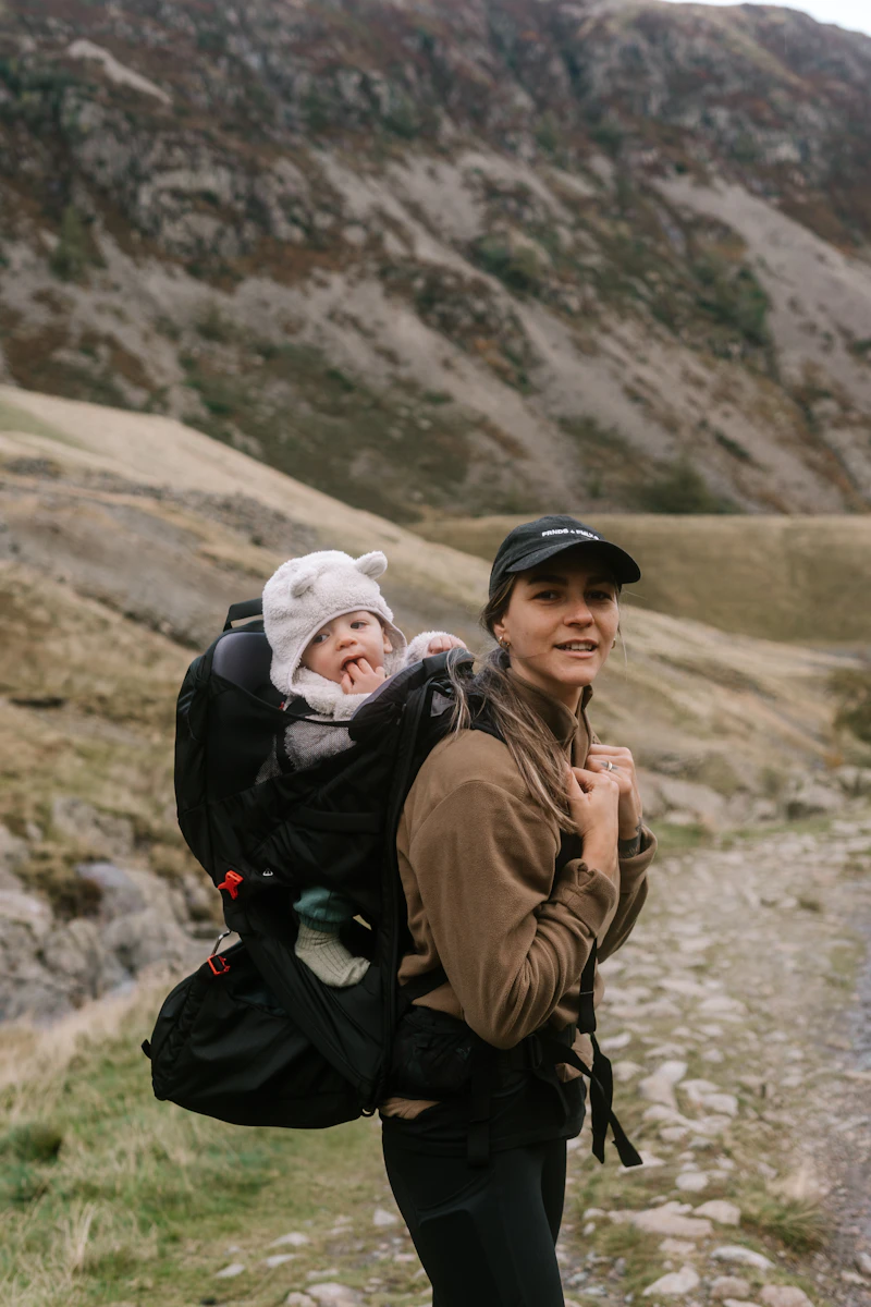 Parent hiking on a trail with a child in a carrier
