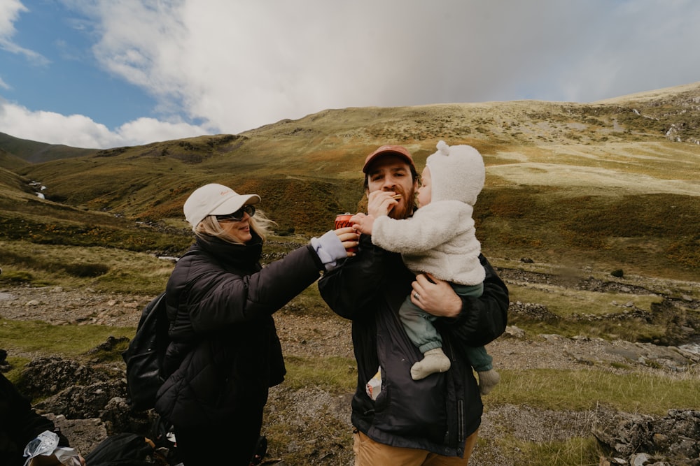 a man and woman holding a baby