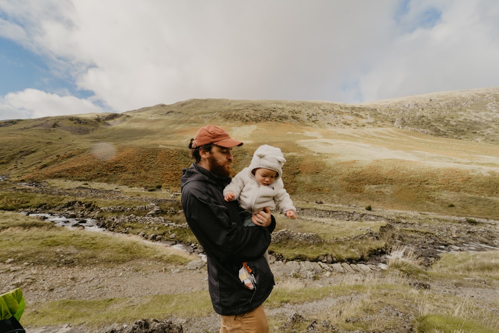 a man carrying a baby