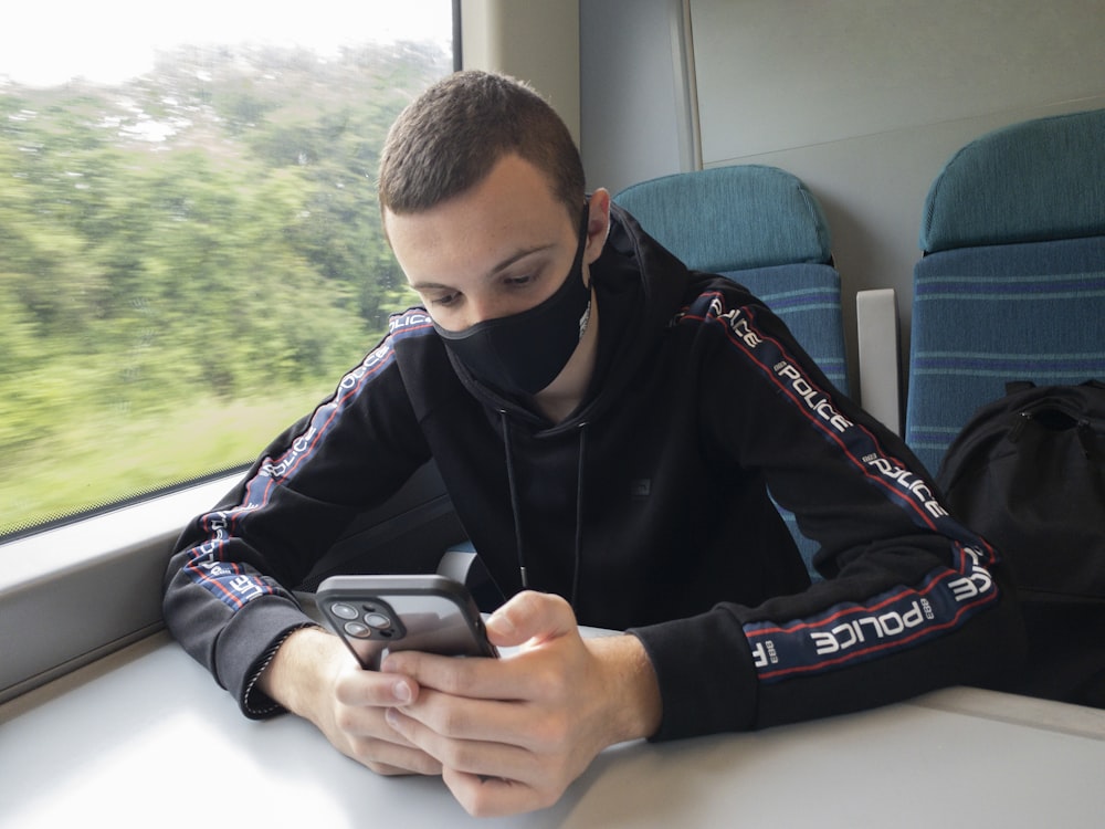 a person sitting on a train looking at the phone
