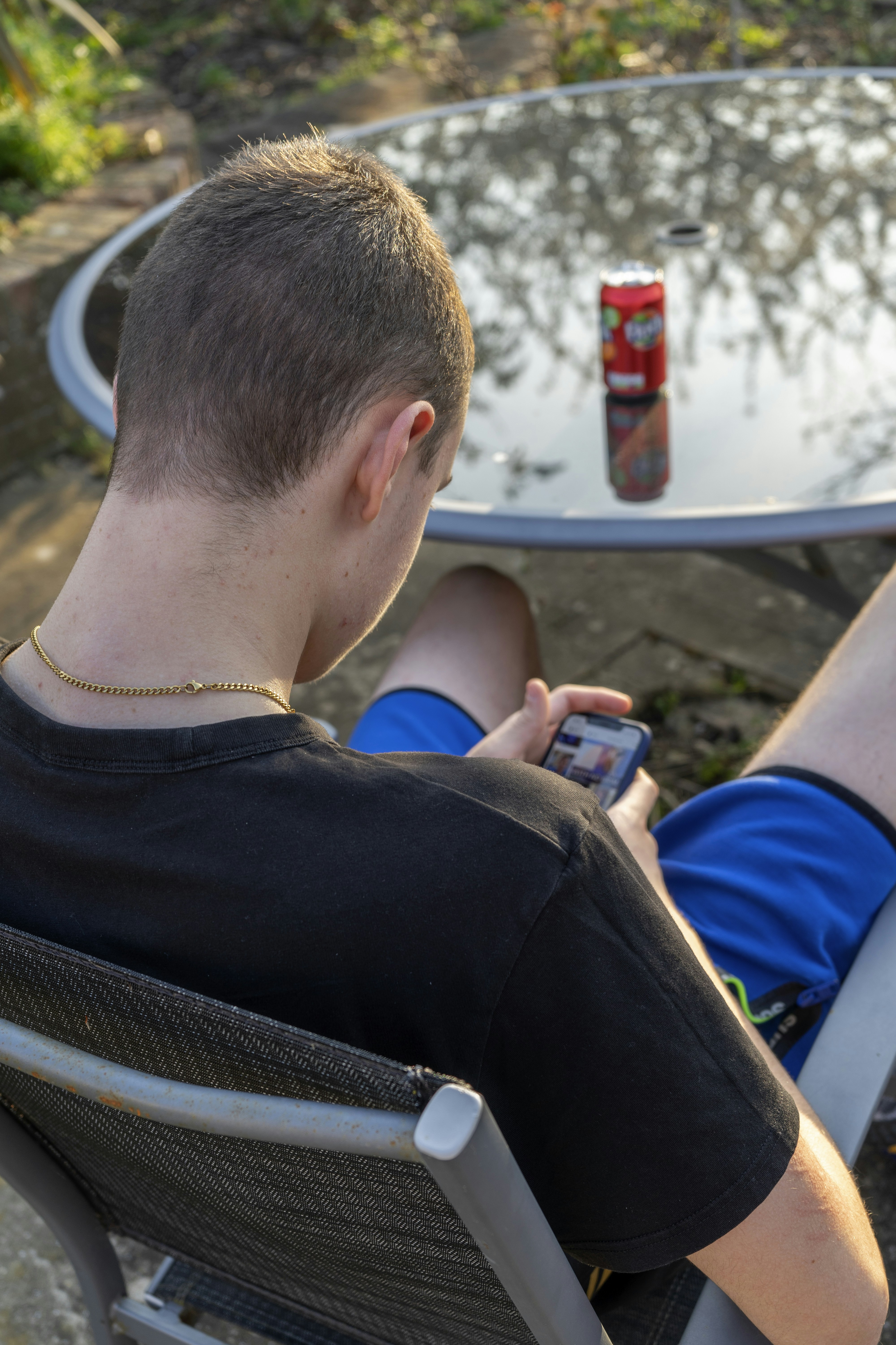 a man sitting in a chair with a soda can