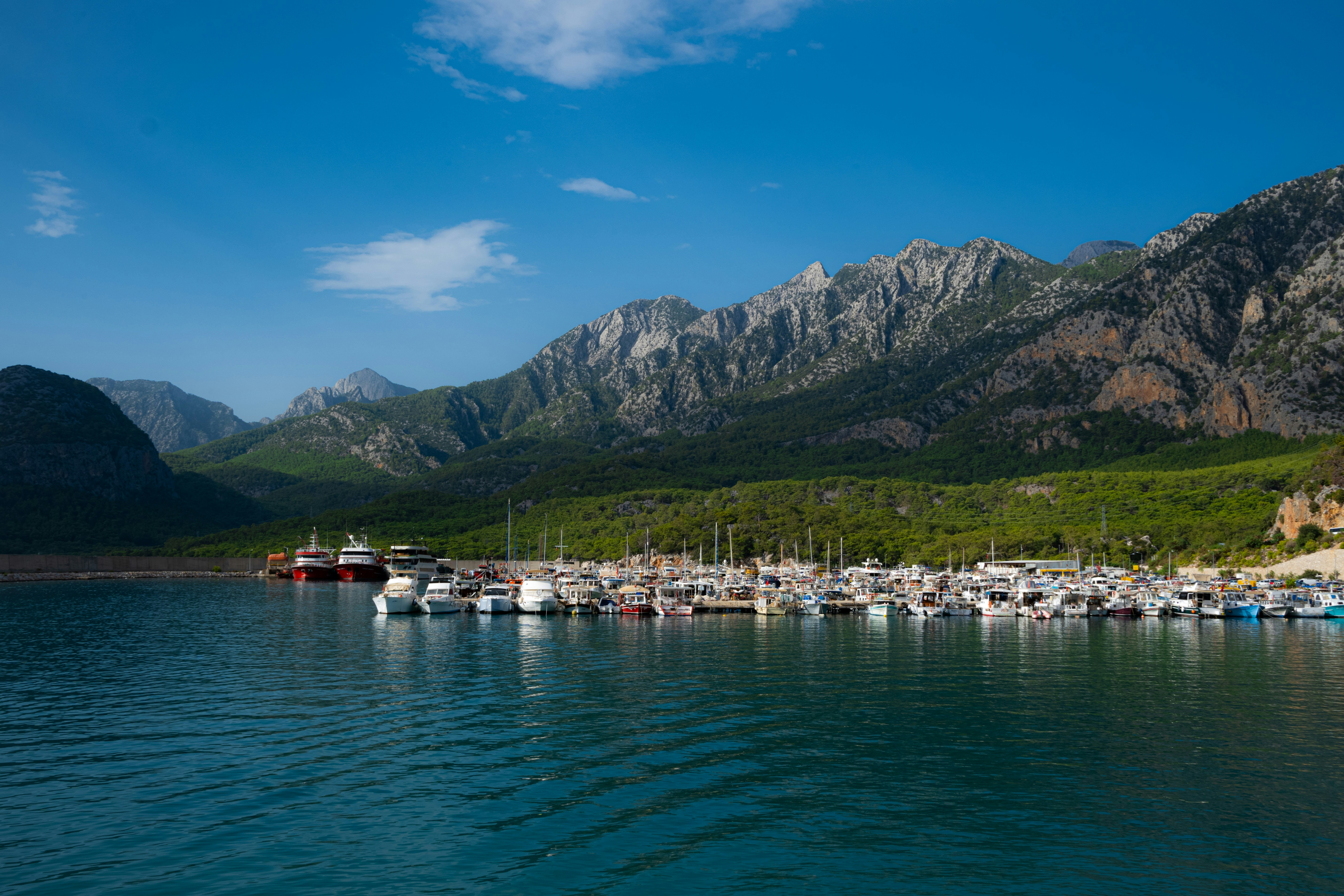 a body of water with boats in it and mountains in the background