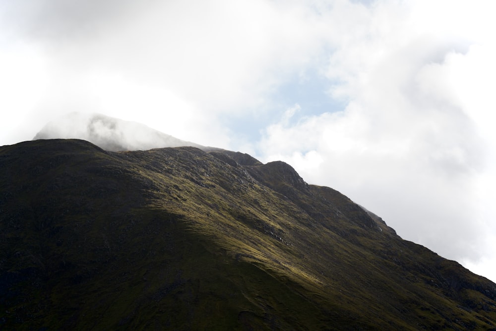 une montagne avec des nuages au-dessus d’elle