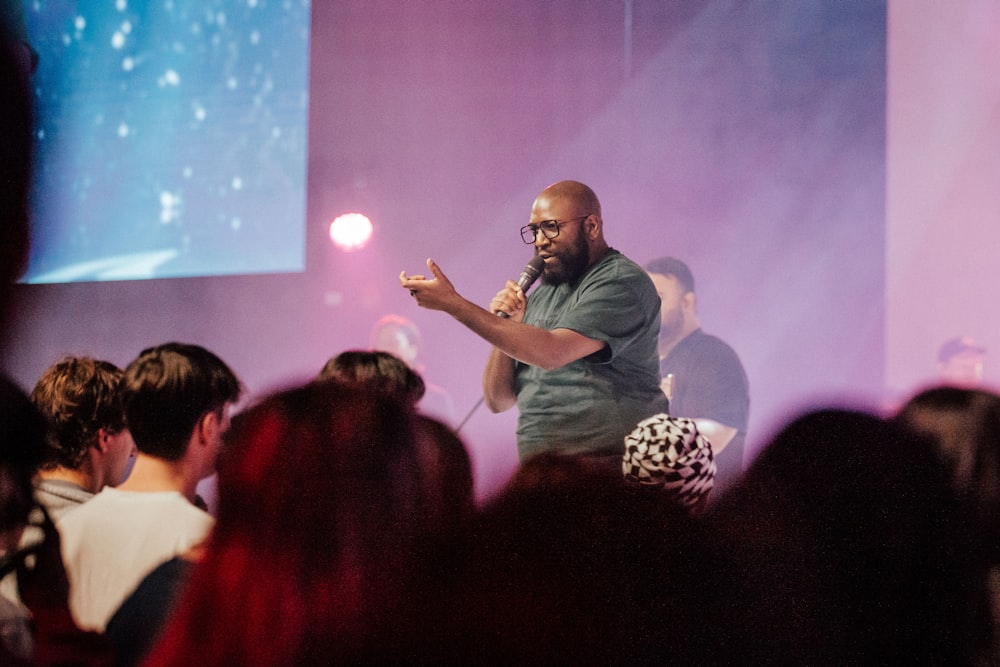 a person standing in front of a crowd with the hands up