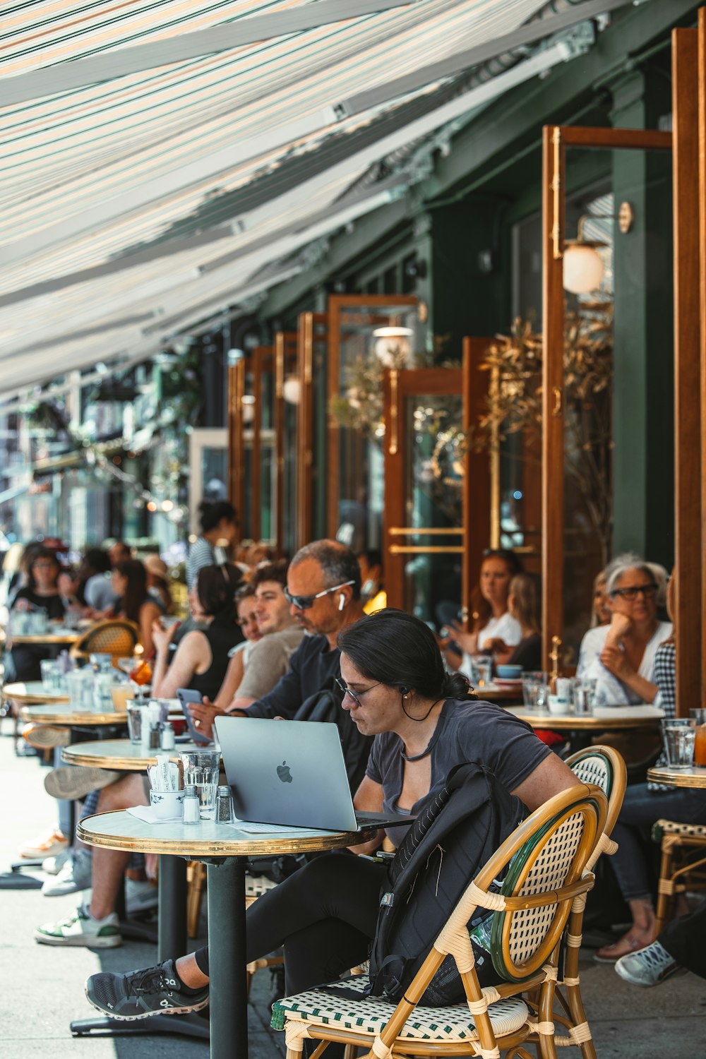 people sitting at tables with a laptop