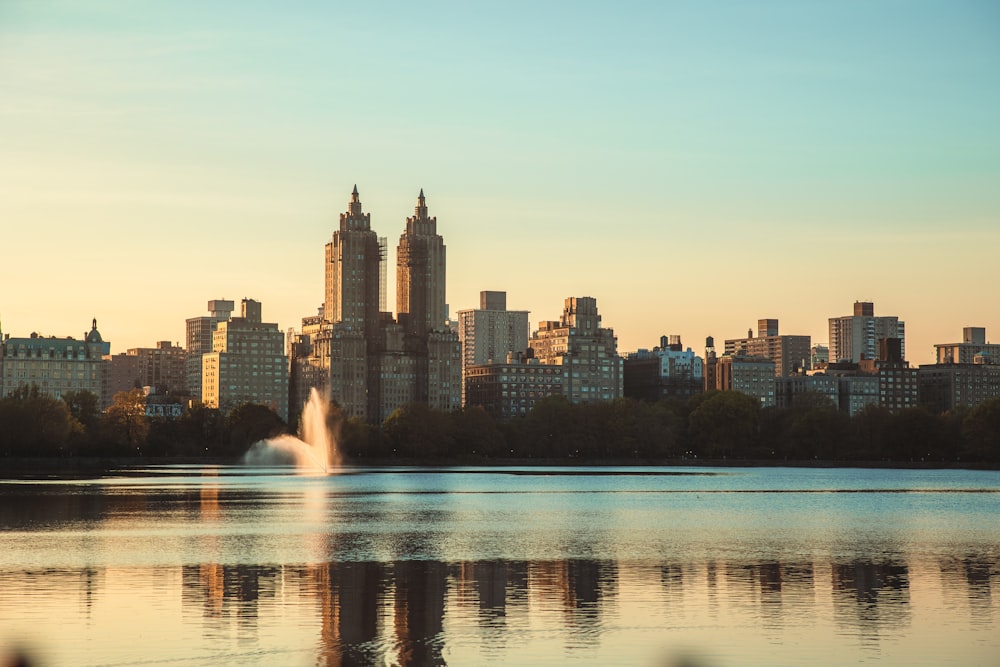 a city skyline with a fountain in the foreground