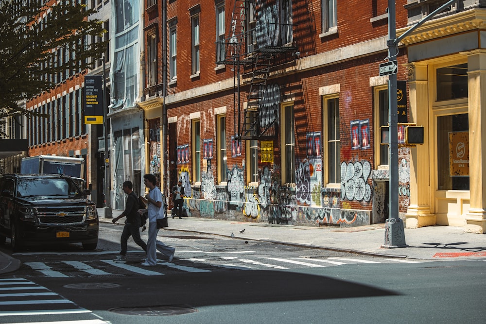 a couple of people walk across a crosswalk