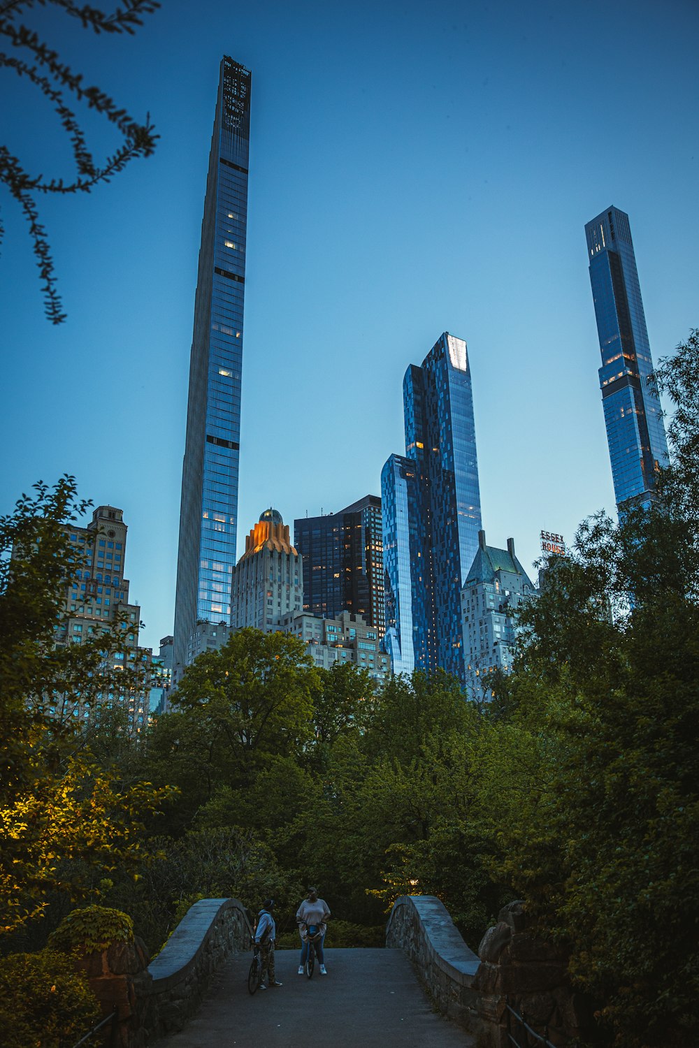 a group of people walking on a path in front of a city