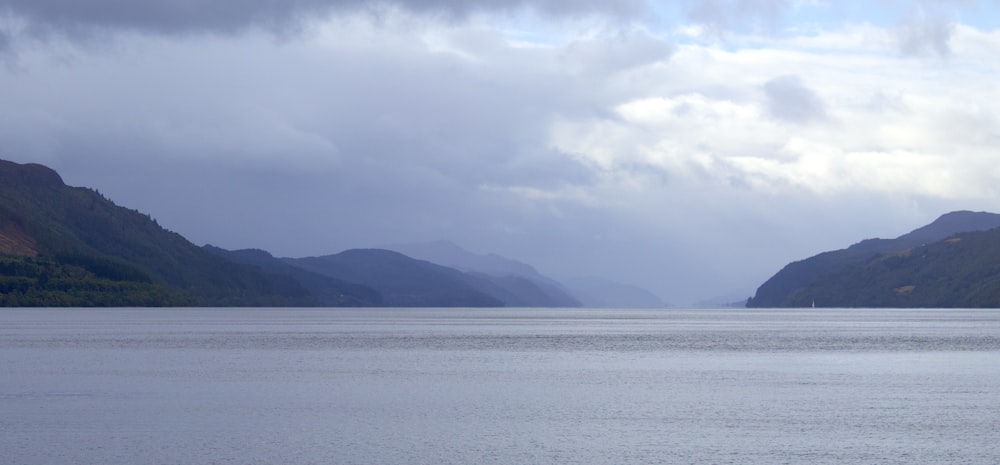 a body of water with mountains in the background