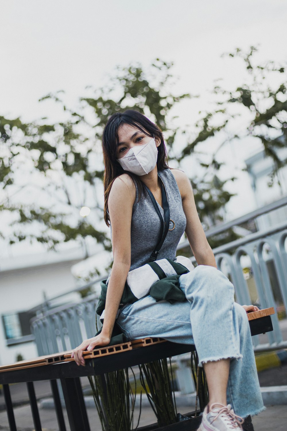 a woman with a mask sitting on a bench