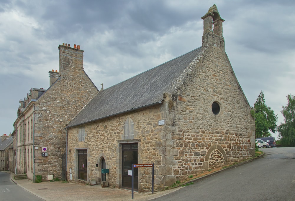 a stone building with a stone wall with Woolsthorpe Manor in the background