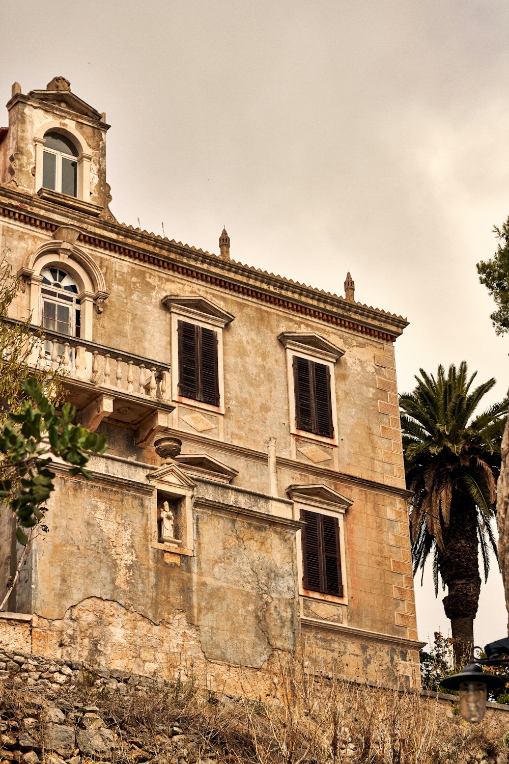 a stone building with a palm tree