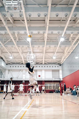 Action shot of a male volleyball player spiking the ball wearing vibrant gear from volovibe.