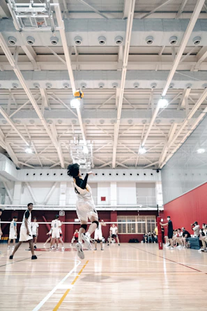 A volleyball player from Detty Vôlei jumping to spike the ball during a sunny match