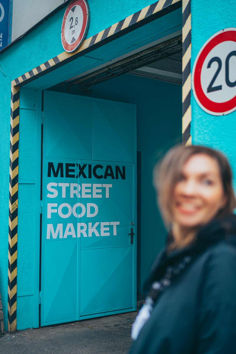 a person standing in front of a blue door with a sign on it