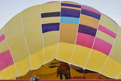 Team assembling a large inflatable advertising balloon at a busy event.