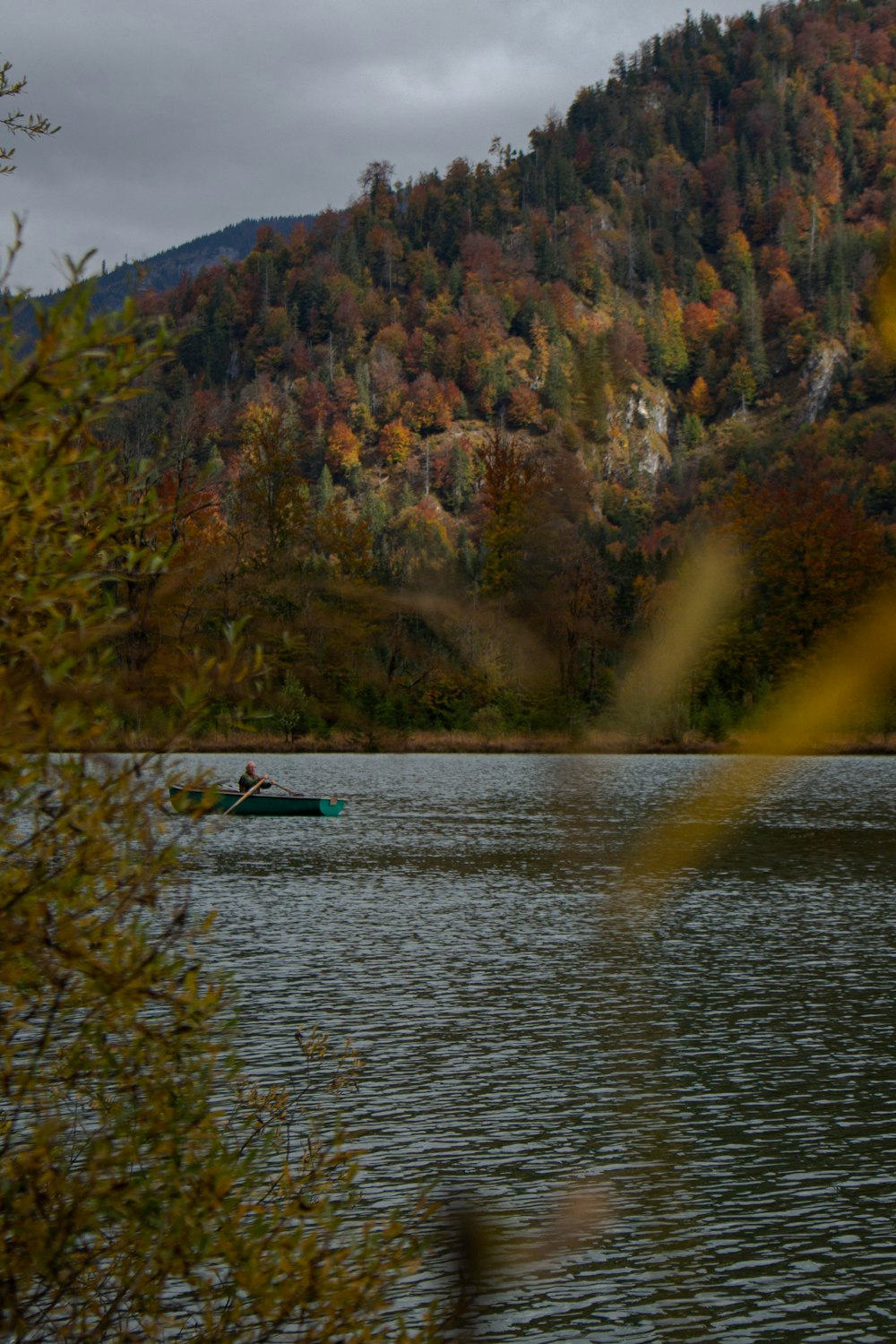 Una persona in un kayak in un lago circondato da alberi