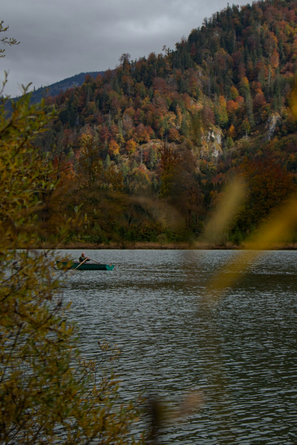 a person in a kayak in a lake surrounded by trees