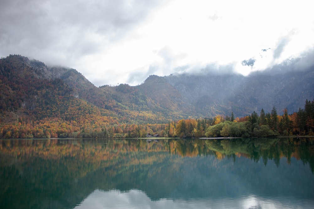 a lake with trees and mountains in the background