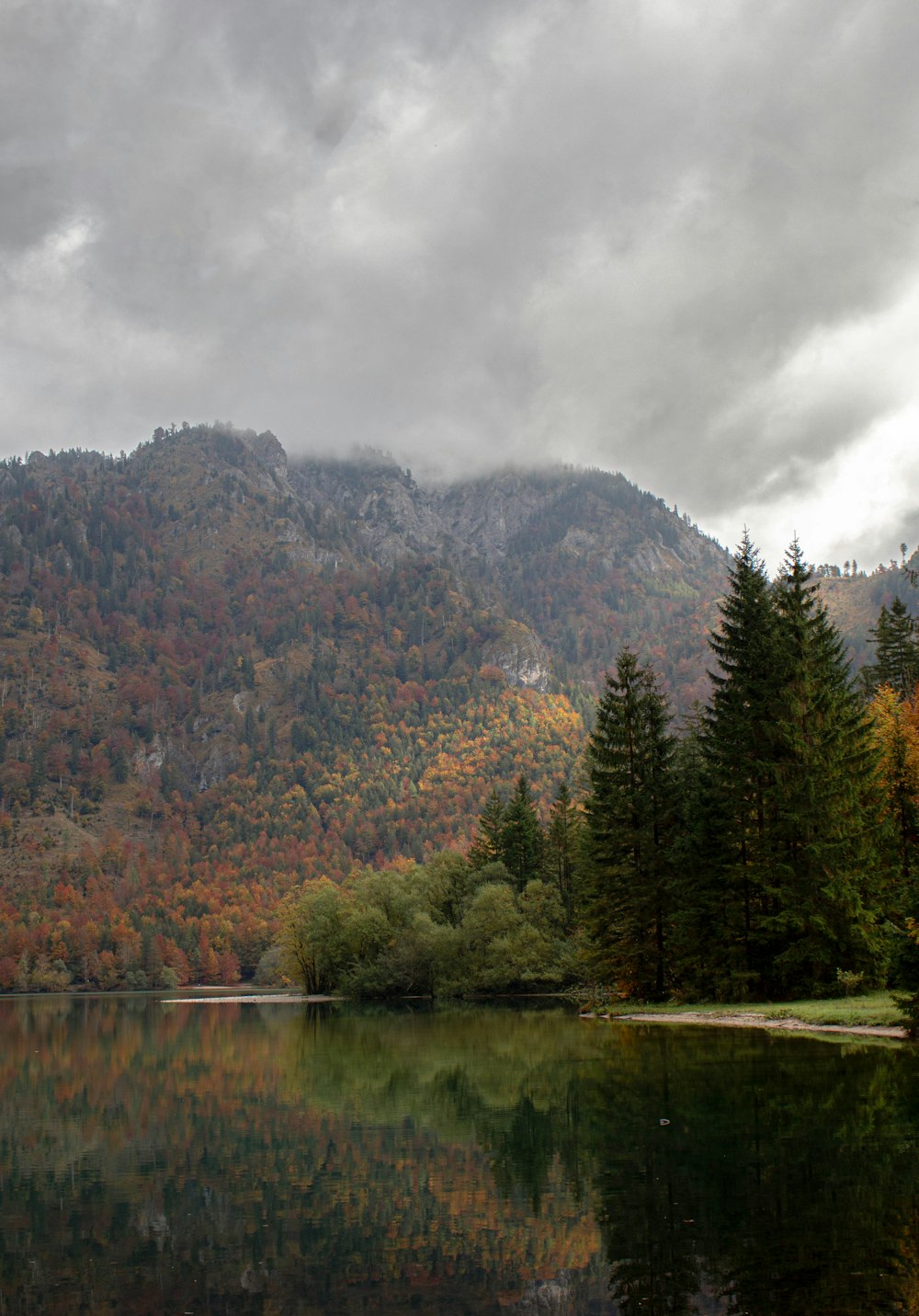 a lake with trees and mountains in the background