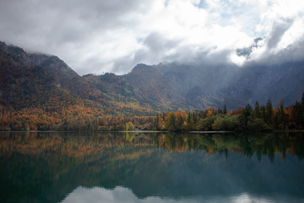 a lake with trees and mountains in the background