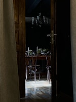 A cozy dining area showcasing refinished hardwood floors and a new, elegant door.