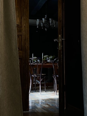 A cozy dining area showcasing refinished hardwood floors and a new, elegant door.