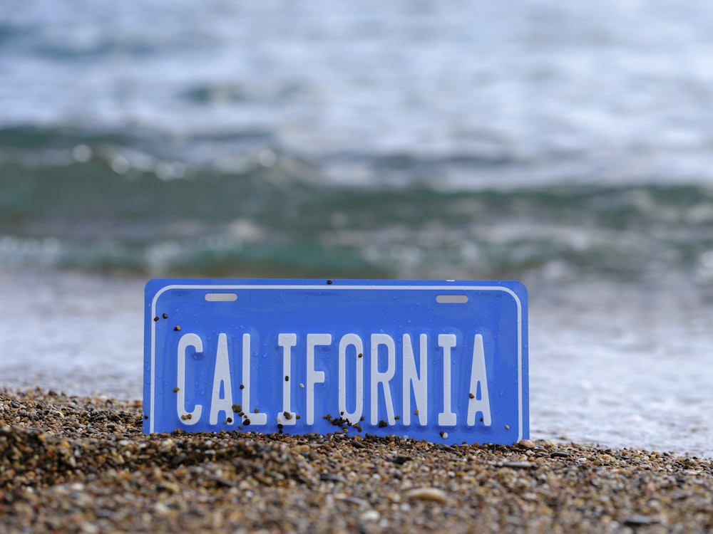 a blue sign on a beach