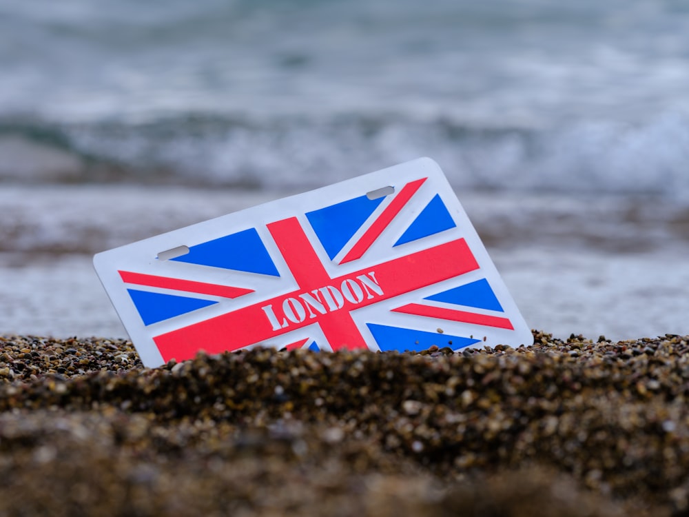 a red and white box on a rocky beach