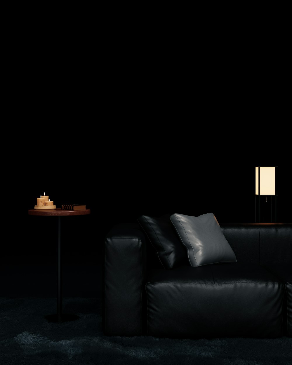 a black couch with a table and a lamp on the side