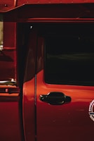 Close-up of a freshly repaired car door with a glossy finish in a workshop.