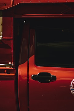 Close-up of a car door freshly painted in glossy red.