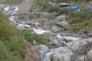 Colorful tents and eco-lodges nestled beside the river, with adventurers relaxing after a day of thrills