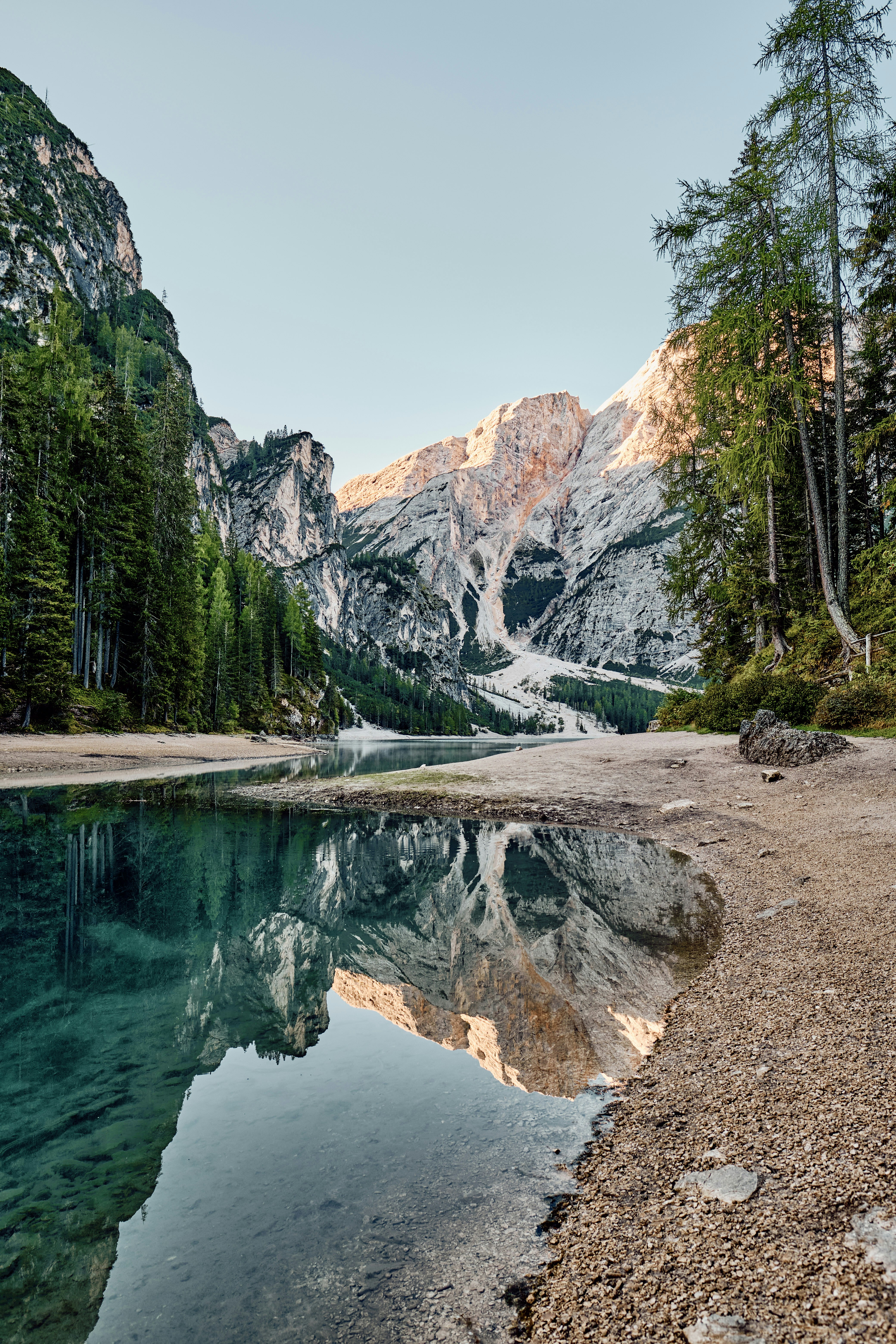 um corpo de água com árvores e montanhas ao fundo