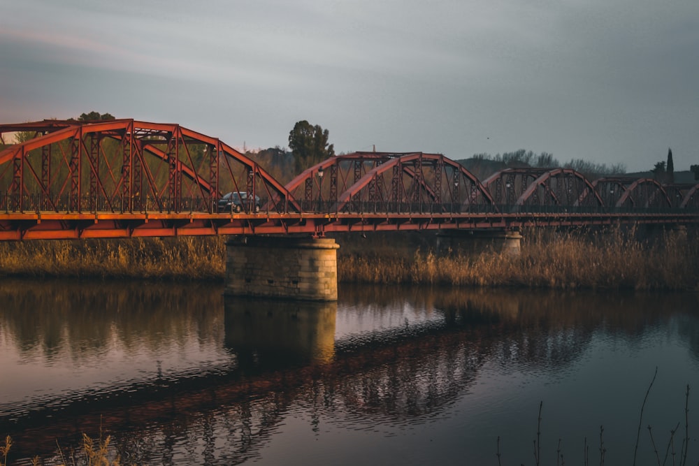 a red bridge over a river