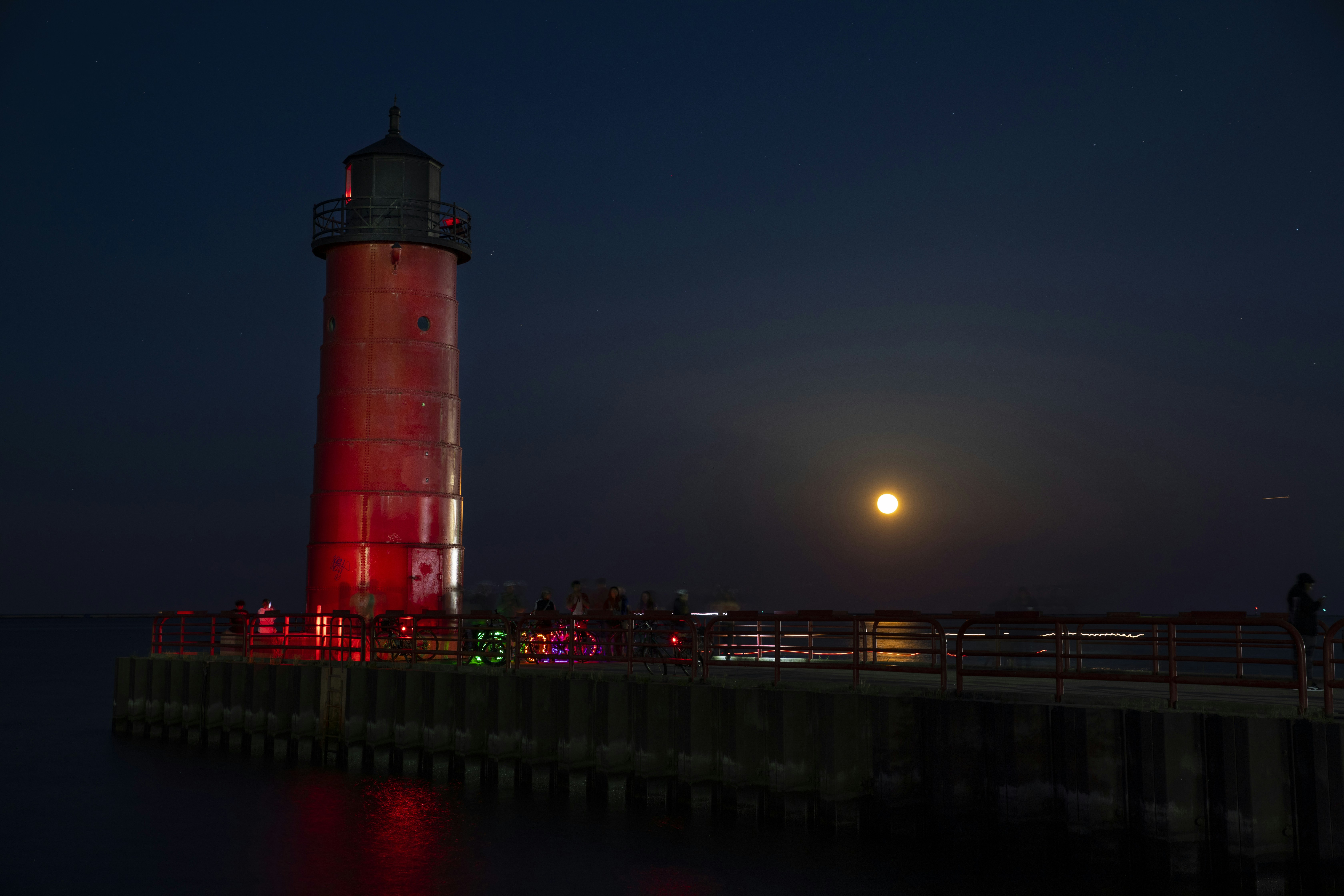 a lighthouse on a pier, Full moonrise over Lake Michigan at Milwaukee Pierhead Lighthouse.