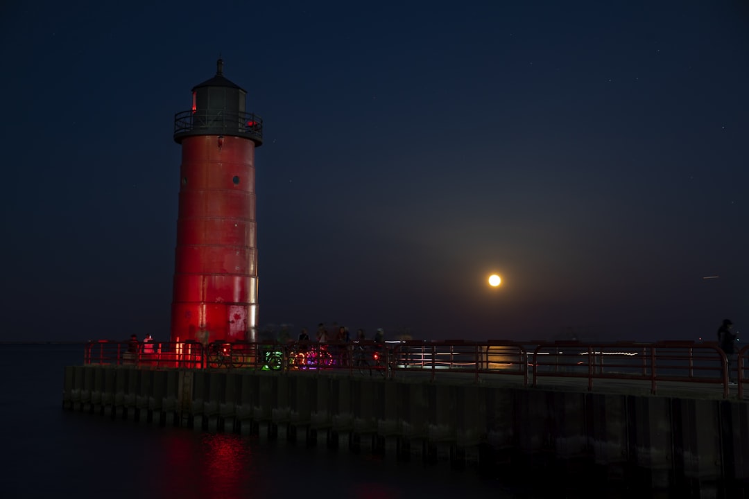 a lighthouse on a pier, Full moonrise over Lake Michigan at Milwaukee Pierhead Lighthouse.