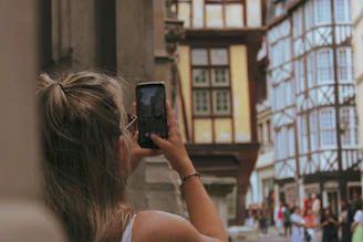 A happy traveler using a smartphone with an active eSIM on a sunny city street.