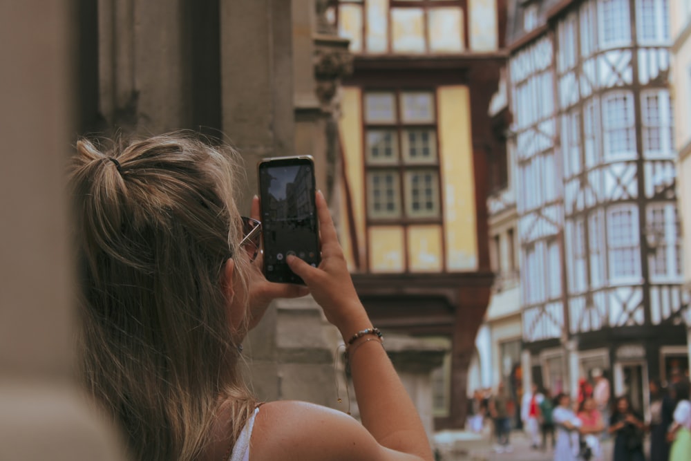 a woman taking a picture of a building