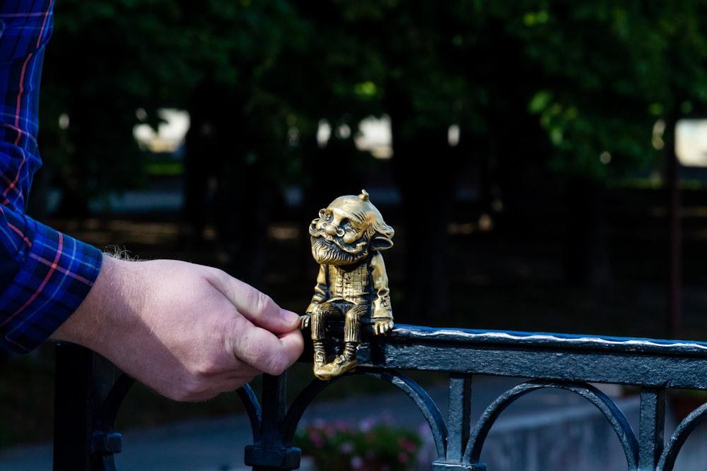 a hand holding a small statue